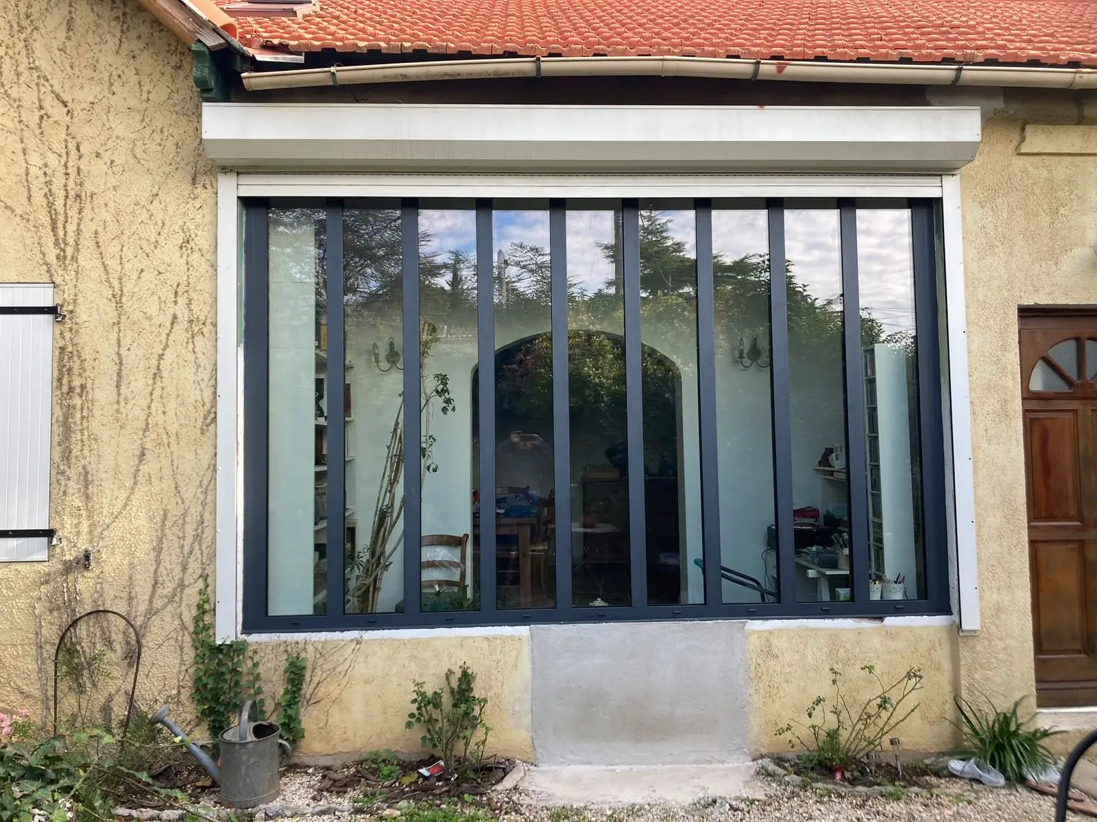 Grande baie vitrée créée dans la façade d'une maison, encadrement neuf